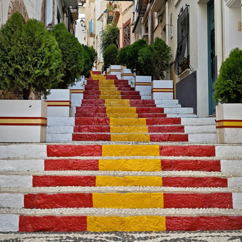 Escaleras pintadas con la bandera de España simbolizando el proceso de regularización de extranjeros 2026